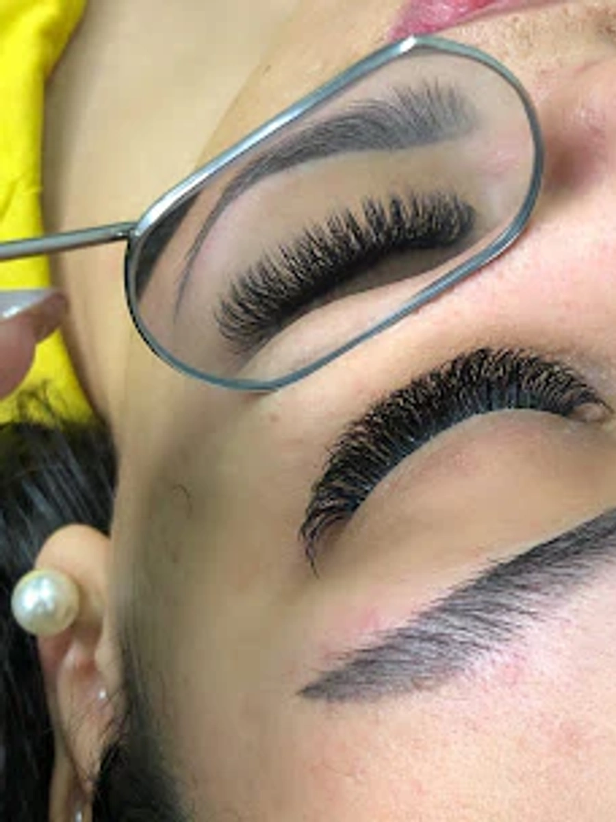 Detalhe de extensão de cílios visto pelo espelho.